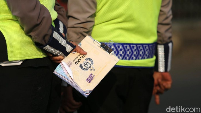 Sanksi Tilang Ganjil Genap Mulai Berlaku Petugas Polisi Lalu Lintas (Polantas) Satlantas Polres Jakarta Timur saat melakukan penilangan pada pengendara mobil yang melanggar aturan Ganjil-Genap di Simpang Cawang, Jakarta Timur, Senin (10/8/2020). Sanksi tilang bagi pelanggar pembatasan kendaraan bermotor berdasarkan nomor polisi ganjil dan genap diberlakukan lagi di Jakarta mulai hari ini. Pembatasan itu sebelumnya dicabut sementara sejak pertengahan Maret lalu karena adanya pandemi Covid-19 yang berujung pada penerapan pembatasan sosial berskala besar (PSBB).