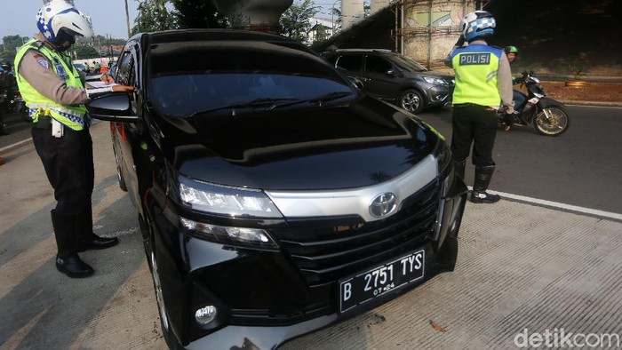 Sanksi Tilang Ganjil Genap Mulai Berlaku Petugas Polisi Lalu Lintas (Polantas) Satlantas Polres Jakarta Timur saat melakukan penilangan pada pengendara mobil yang melanggar aturan Ganjil-Genap di Simpang Cawang, Jakarta Timur, Senin (10/8/2020). Sanksi tilang bagi pelanggar pembatasan kendaraan bermotor berdasarkan nomor polisi ganjil dan genap diberlakukan lagi di Jakarta mulai hari ini. Pembatasan itu sebelumnya dicabut sementara sejak pertengahan Maret lalu karena adanya pandemi Covid-19 yang berujung pada penerapan pembatasan sosial berskala besar (PSBB).