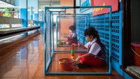 Saat bermain, anak-anak ini harus masuk ke dalam kotak plastik demi mengedepankan physical distancing. Walaupun begitu anak-anak ini tetap semangat untuk bermain.