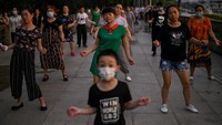 Sementara di tempat lain, terlihat warga menari di samping Sungai Yangtze di Wuhan di provinsi Hubei, China. Pemulihan kota sejak karantina 76 hari dicabut pada bulan April membuat kehidupan di Wuhan mulai berdenyut. Warga kembali ke jalan. (Foto: AFP/HECTOR RETAMAL)