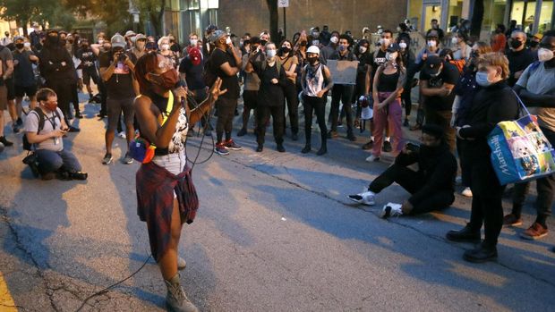 Ariel Atkins, a lead organizer for Black Lives Matter Chicago, leads a protest Monday, Aug. 10, 2020, outside the Chicago Police Department's District 1 station in Chicago. (AP Photo/Charles Rex Arbogast)