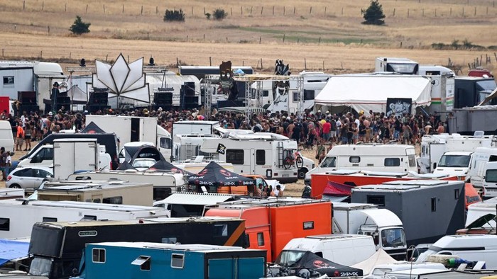 People gather with their tents, vehicles and camping cars, for a rave party, on an agricultural land in Causse Mejean, in the heart of the Cevennes National Park, southern France on August 10, 2020, despite the limitation of gatherings linked to COVID-19, the novel coronavirus. - The rally gathered up to 10,000 people announced the prefecture of Lozere. Starting from August 9, 2020 at 8:00 am, the gendarmes had blocked the access to prevent other people from joining the party where there were also very young children, according to the prefect. Two Covid-19 screening centers are being set up in transit areas, near the site, to be operational on Tuesday morning, also said Ms. Hatsch. (Photo by Pascal GUYOT / AFP)