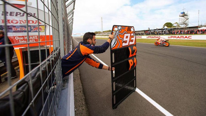 Mekanik tim balap sedang menunjukkan papan pit board Mekanik tim balap sedang menunjukkan papan pit board