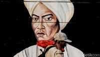 Seorang warga melewati mural bergambar Pangeran Diponegoro.  