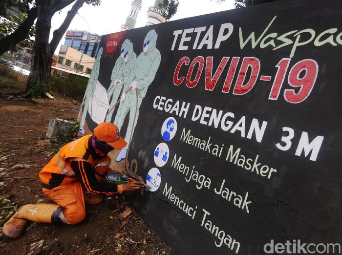 Petugas Pekerja Penanganan Sarana dan Prasarana Umum (PPSU) Kelurahan Bukit Duri, Jakarta menyelesaikan pembuatan mural tentang Covid-19, Jakarta, Selasa  (11/8/2020). Jumlah pasien positif Covid-19 di DKI Jakarta per Senin (10/8/2020) adalah 26.162 orang. Angka ini tertinggi di Indonesia. Dari total kasus positif itu, 16.446 orang dinyatakan telah sembuh, sedangkan 940 orang dilaporkan meninggal dunia. Sementara itu, sebanyak 8.807 pasien masih menjalani perawatan di rumah sakit maupun menjalani isolasi mandiri.