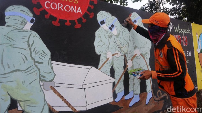 Mural Ingatkan Bahaya COVID-19 Petugas Pekerja Penanganan Sarana dan Prasarana Umum (PPSU) Kelurahan Bukit Duri, Jakarta menyelesaikan pembuatan mural tentang Covid-19, Jakarta, Selasa (11/8/2020). Jumlah pasien positif Covid-19 di DKI Jakarta per Senin (10/8/2020) adalah 26.162 orang. Angka ini tertinggi di Indonesia. Dari total kasus positif itu, 16.446 orang dinyatakan telah sembuh, sedangkan 940 orang dilaporkan meninggal dunia. Sementara itu, sebanyak 8.807 pasien masih menjalani perawatan di rumah sakit maupun menjalani isolasi mandiri.
