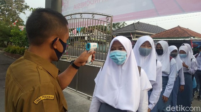 Para siswa di Kuningan dicek suhu sebelum masuk ke sekolah.