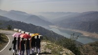 Para pelajar berjalan di Bendungan Tehri yang dialiri air Sungai Bhagirathi. Bhagirathi adalah salah satu dari dua sumber yang membentuk Sungai Gangga, yang lainnya adalah sungai Alaknanda.