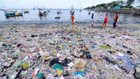Nelayan berjalan di antara tumpukan sampah di Pelabuhan Muncar, Banyuwangi, Jawa Timur, Selasa (11/8/2020).