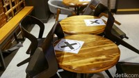Aturan jaga jarak tertera di meja suatu restoran di Trans Studio Mall Bali.