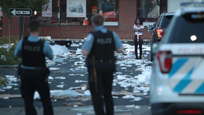 CHICAGO, ILLINOIS - AUGUST 10: A person stands near a looted store after parts of the city had widespread looting and vandalism, on August 10, 2020 in Chicago, Illinois. Police made several arrests during the night of unrest and recovered at least one firearm. Scott Olson/Getty Images/AFP