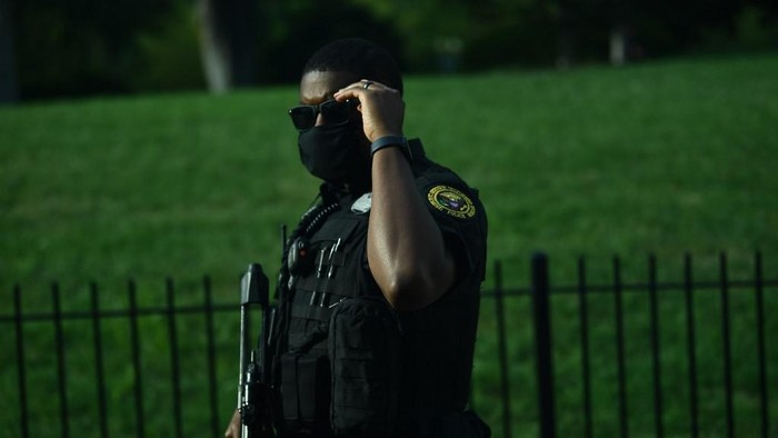 A member of the US Secret Service takes up position outside the Brady Briefing Room as the White House is locked down in Washington, DC, on August 10, 2020. - Secret Service guards shot a person, who was apparently armed, outside the White House on August 10, 2020. President Donald Trump said just after being briefly evacuated in the middle of a press conference. (Photo by Brendan Smialowski / AFP)