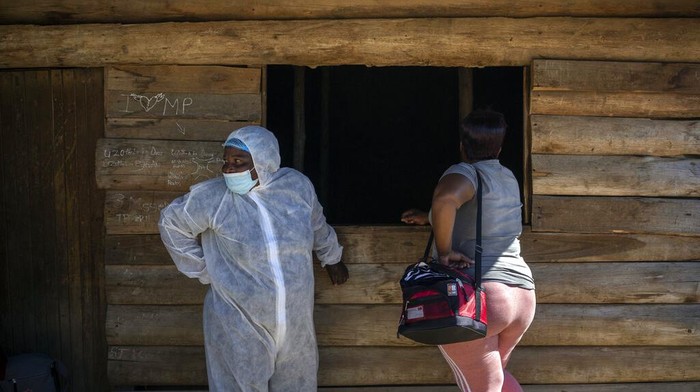 A nurse stands next to a HIV-positive patient outside a gazebo used as a mobile HIV clinic in Ngodwana, South Africa, Thursday, July 2, 2020. Across Africa and around the world, the COVID-19 pandemic has disrupted the supply of antiretroviral drugs to many of the more than 24 million people who take them, endangering their lives. An estimated 7.7 million people in South Africa are HIV positive, the largest number in the world, and 62% of them take the antiretroviral drugs that suppress the virus and prevent transmission. (AP Photo/Bram Janssen)
