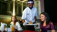 Sembari menikmati angin malam, beberapa hidangan andalan restoran tersebut disajikan oleh pelayanan yang mengenakan masker, face shield, dan sarung tangan.  