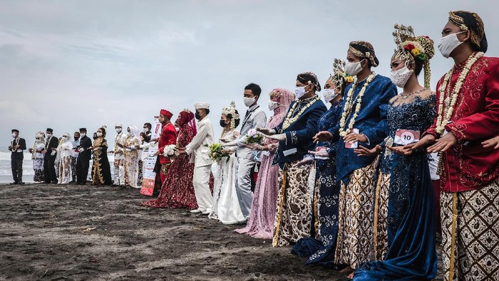 Momen Nikah Massal Jelang HUT RI di Yogyakarta Momen pernikahan massal dalam rangka HUT RI digelar di pantai Cemara Sewu, Yogyakarta. Wajah semringah terpancar dari para pasangan.