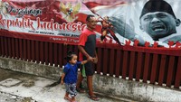 Spanduk HUT RI menghiasi permukiman mewah di Jakarta Selatan, Rabu (12/8). Spanduk itu bergambar presiden pertama Republik Indonesia Soekarno dan pahlawan yang sedang mengibarkan bendera merah putih.