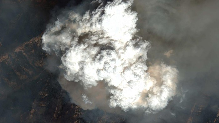 Potret Asap Pekat Akibat Kebakaran Hutan Colorado A man watches and takes photos of the Grizzly Creek Fire as it blows up in No Name Canyon in the afternoon after the fire initially started on Interstate 70 on Monday near Glenwood Springs, Colo., Tuesday, Aug. 11, 2020. (Chelsea Self/Glenwood Springs Post Independent via AP)