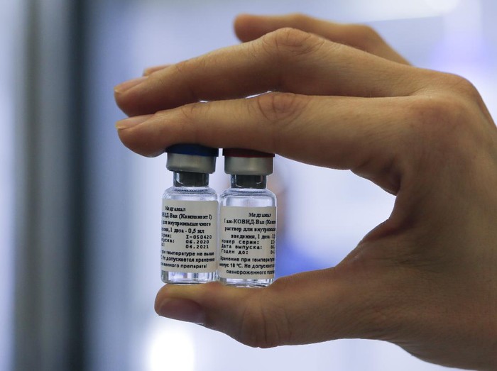 In this handout photo taken on Thursday, Aug. 6, 2020, and provided by Russian Direct Investment Fund, an employee shows a new vaccine at the Nikolai Gamaleya National Center of Epidemiology and Microbiology in Moscow, Russia. Russia on Tuesday, Aug. 11 became the first country to approve a coronavirus vaccine for use in tens of thousands of its citizens despite international skepticism about injections that have not completed clinical trials and were studied in only dozens of people for less than two months. (Alexander Zemlianichenko Jr/ Russian Direct Investment Fund via AP)