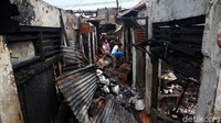 Warga mencari barang-barang yang masih bisa diselamatkan di antara puing-puing sisa kebakaran.
