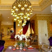 Ruang tamu dihiasi lampu gantung besar dan bantal-bantal beraksen ungu sehingga tak terasa monoton. (Foto: YouTube/Boy William)