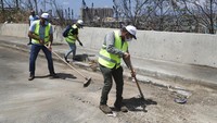 Di beberapa tempat, mereka menyapu jalan dan mengangkut puing-puing sementara pasukan keamanan atau tentara berdiri di dekat mereka untuk mengawasi.  