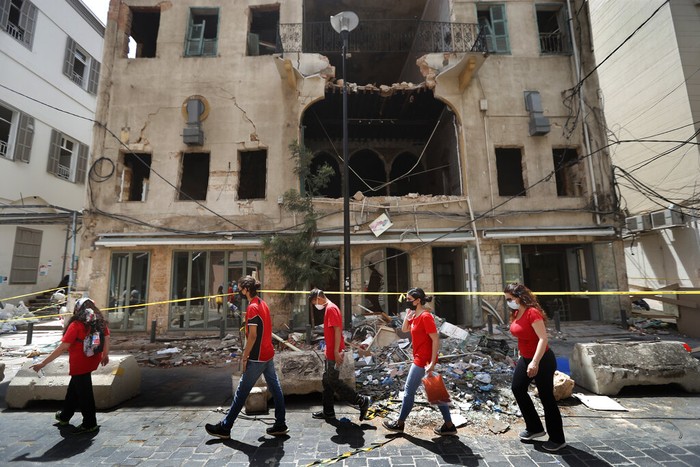 Lebanon Helping Themselves People who volunteered to help clean damaged homes and give other assistance, gather on a street that was damaged by last week's explosion, in Beirut, Lebanon, Tuesday, Aug. 11, 2020. The explosion that tore through Beirut left around a quarter of a million people with homes unfit to live in. In the absence of the state, residents of Beirut opened their homes to relatives, friends and neighbors. And on the streets, it was young volunteers with brooms and shovels, not government workers, who cleared the littered streets. (AP Photo/Hussein Malla)