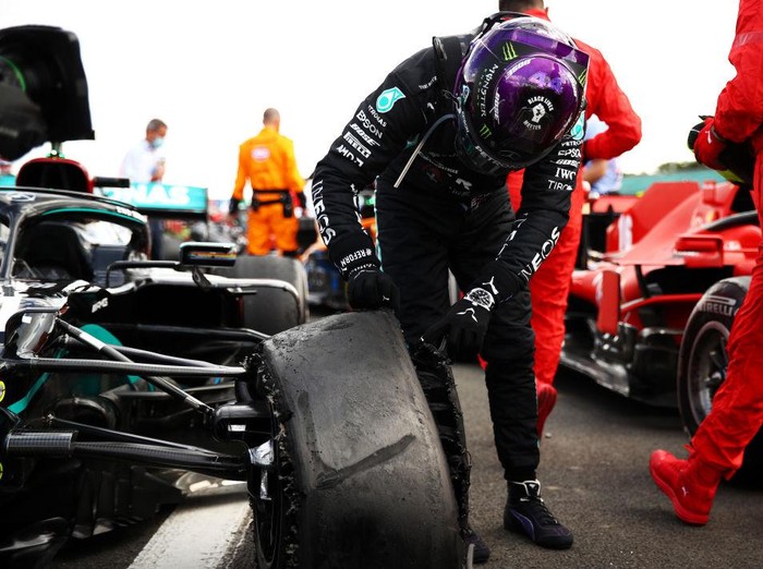 NORTHAMPTON, ENGLAND - AUGUST 02: Race winner Lewis Hamilton of Great Britain and Mercedes GP inspects his punctured tyre in parc ferme during the F1 Grand Prix of Great Britain at Silverstone on August 02, 2020 in Northampton, England. (Photo by Bryn Lennon/Getty Images)