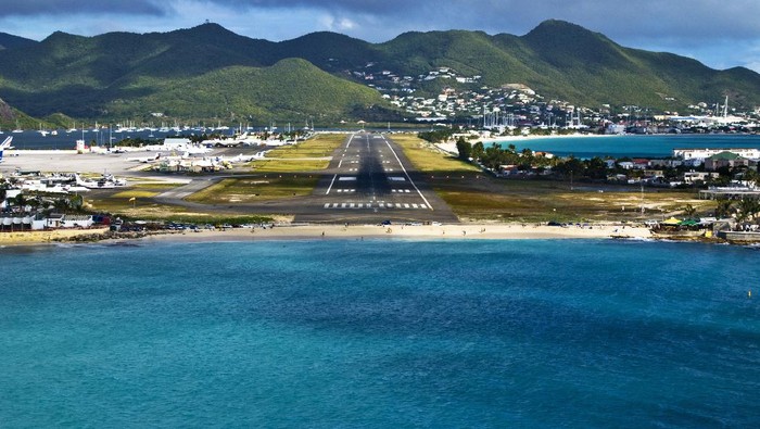 St Maarten, Netherlands - February 13, 2016: beach observe low flying airplanes landing near Maho Beach on island of St Maarten in the Caribbean