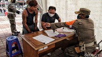 Petugus mendata setiap warga yang tidak memakai masker.