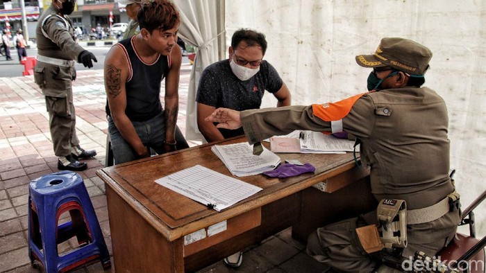 Sejumlah petugas Satpol PP tingkat kota melakukan razia pendisiplinan pemakaian masker di kawasan Danau Sunter, Jakarta Utara, Rabu (13/8). Kegiatan tersebut bertujuan memberikan ketegasan kepada para pengendara yang tidak tertib memakai masker di masa PSBB Transisi ini.