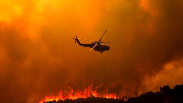 Firefighters work in the smoke and haze and embers from the Lake Hughes fire in Angeles National Forest on Wednesday, Aug. 12, 2020, north of Santa Clarita, Calif. (AP Photo/Ringo H.W. Chiu)