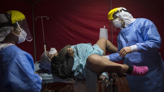Potret Proses Persalinan Pasien COVID-19 yang Bikin Haru di Peru Proses persalinan di tengah pandemi COVID-19 dilakukan dengan terapkan protokol kesehatan. Penanganan khusus diberikan bagi pasien COVID-19 yang akan melahirkan