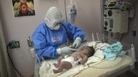 Seorang ahli neonatologi tengah memeriksa kondisi bayi yang baru lahir di National Perinatal and Maternal Institute yang berada di Kota Lima, Peru. Seperti diketahui, rumah sakit bersalin itu mendedikasikan setengah fasilitas kesehatan di sana untuk membantu proses persalinan ibu-ibu yang terinfeksi COVID-19.