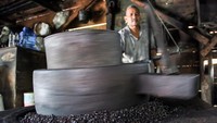 Pekerja Usaha Kecil Menengah (UKM) menggiling biji kopi robusta di tempat produksi bubuk kopi tradisional Desa Kandang, Lhokseumawe, Aceh, Rabu (12/8/2020).