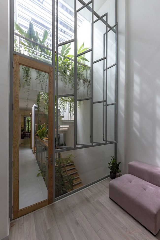 Rumah ini banyak menggunakan elemen kaca transparan untuk memberi kesan tiap ruangan lebih luas. Foto: Thiet Vu/Khuon Studio