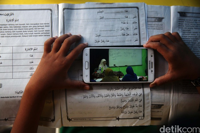 Warga Pondok Kelapa, Jakarta Timur gotong royong membangun tenda pintar. Di tenda ini pelajar mendapat WiFi gratis untuk belajar online.