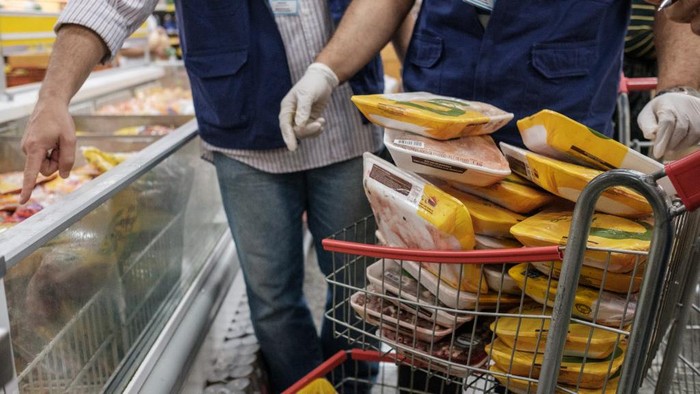 The staff of Rio de Janeiro states consumer protection agency, PROCON, inspect and remove chicken products that are not frozen from a freezer at a supermarket in Rio de Janeiro, Brazil, on March 24, 2017. - Brazil, the worlds biggest beef and poultry exporter, has been hit by allegations of corrupt practices in its meat industry. Police have halted exports by 21 meat processers suspected of bribing inspectors to issue them bogus health certificates for rotten meat. (Photo by Yasuyoshi Chiba / AFP)