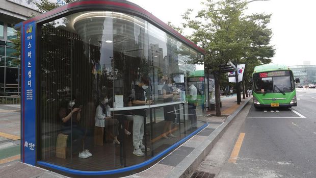 A bus shelter designed to block people with fever amid a spread of the coronavirus, is installed at a bus stop in Seoul, South Korea, Friday, Aug. 14, 2020. The glass panels-covered bus stops at a Seoul district, are equipped with thermal cameras that screen people for fevers and also automatic doors that doesn't let in any one with high temperatures. (AP Photo/Ahn Young-joon)