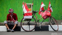 Tarjono, seorang pedagang jagung manis menghias sepeda dagangannya dengan atribut merah putih, Jakarta, Jumat (14/8/2020).
