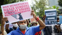 Peserta aksi menggelar unjuk rasa dengan menerapkan protokol kesehatan seperti memakai masker.