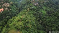 Dari kejauhan kita dapat melihat hamparan pohon serta hotel dan villa di tebing-tebing yang tinggi.