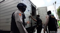 Polisi memerika barang bawaan mobil boks yang melintas.