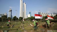 Para petugas tampak memotong rumput di kawasan TPU Karet Bivak, Jakarta.