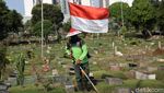 Aksi Petugas Bersihkan TPU Karet Bivak Sambil Bawa Bendera