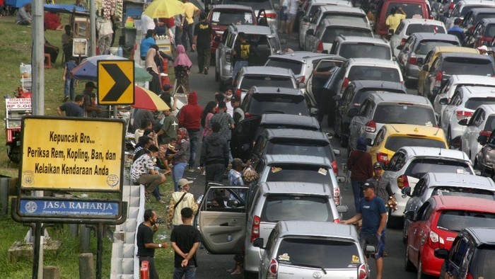 Kepadatan terlihat di jalur puncak Bogor saat masa libur panjang. Tak sedikit wisatawan yang memilih keluar dari kendaraannya sembari menunggu kemacetan reda.