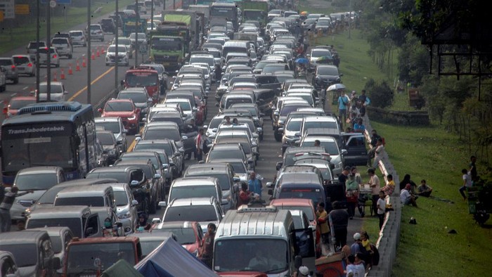 Kepadatan terlihat di jalur puncak Bogor saat masa libur panjang. Tak sedikit wisatawan yang memilih keluar dari kendaraannya sembari menunggu kemacetan reda.