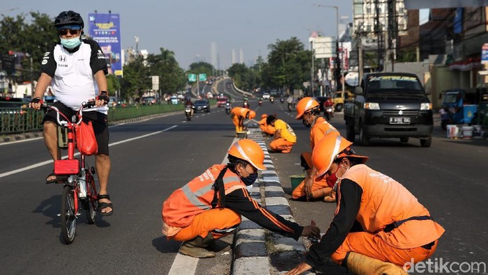 Sejumlah Petugas Penanganan Sarana dan Prasarana Umum (PPSU) mengecat pembatas jalan di Ibu Kota. Hal itu dilakukan untuk kemananan pengguna jalan.