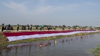Komunitas Pasukan Susur Sungai dan Ekosistem Rancaekek (Passer) membentangkan kain Merah Putih di bantaran sungai Cikijing.