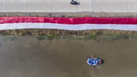 Foto udara kain Merah Putih membentang di Sungai Cikijing, Rancaekek, Kabupaten Bandung, Jawa Barat, Minggu (16/8/2020).