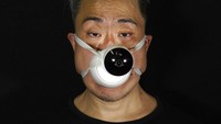 Edmond Kok, seorang desainer kostum dan juga aktor teater di Hong Kong mengenakan masker dari kamera CCTV buatannya.